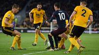 Mesut Ozil dikawal ketat oleh empat pemain Wolves pada laga lanjutan Premier League yang berlangsung di Stadion Molineux, Wolverhampton, Kamis (25/4). Arsenal kalah 1-3 kontra Wolves. (AFP/Paul Ellis)
