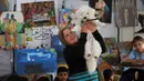 Sementara, penggunaan studio seni diharapkan menjadi ruang ekspresi untuk mengurangi rasa takut dan kecemasan anak-anak pengungsi Palestina. Anak-anak pengungsi Palestina mengikuti sesi konseling psikologis di sebuah studio seni yang menggunakan hewan peliharaan dan burung di daerah Al-Zawaida, Jalur Gaza Tengah, pada Selasa 21 April 2026. (Eyad Baba/AFP)