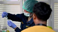 Petugas kesehatan menyiapkan suntikan vaksinasi COVID-19 keempat atau booster kedua untuk petugas bandara di kantor otoritas Bandara Ngurah Rai, dekat Denpasar, Bali, Senin (30/1/2023). Pemerintah Provinsi (Pemprov) Bali melakukan program vaksinasi booster kedua usai dibukanya penerbangan langsung (direct flight) dari China pada Minggu (22/1) lalu. (SONNY TUMBELAKA / AFP)