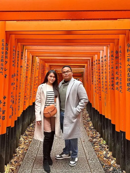 Chen juga tampil mengenakan long coat abu-abu dipadukan inner sweater bergaris hitam serta celana coklat dan knee boots hitamnya. [@chengiovanis]