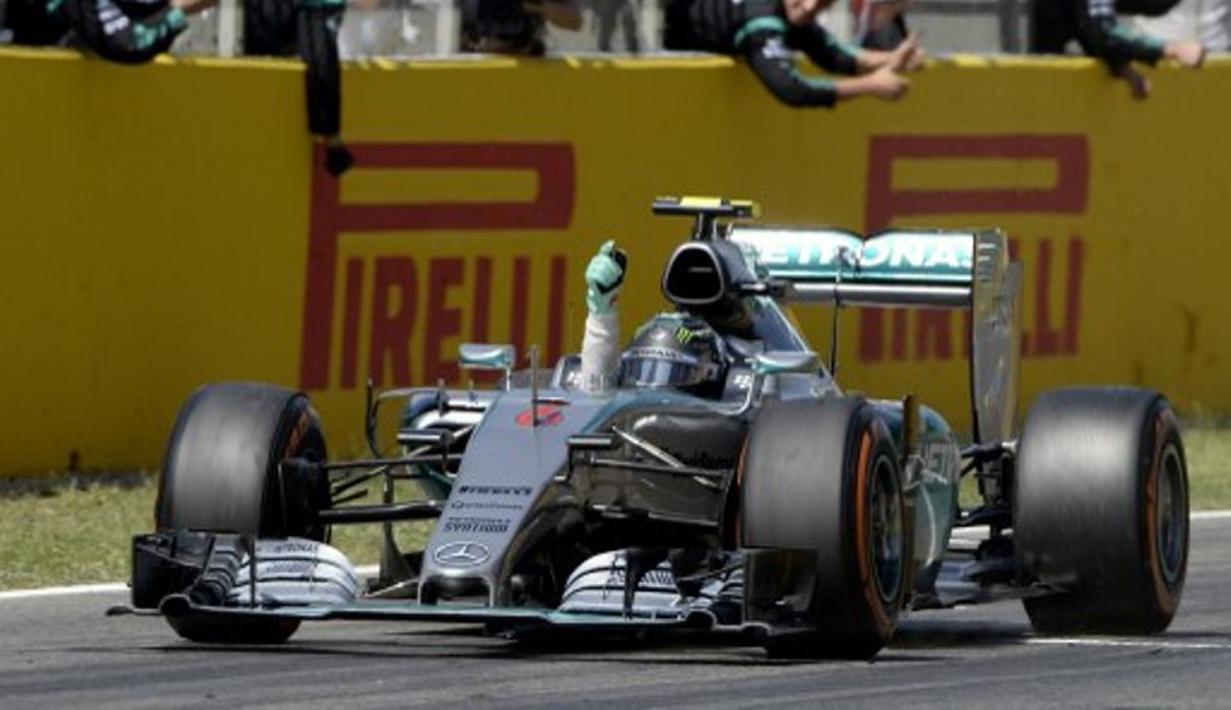 Nico Rosberg mengangkat tangannya setelah menyentuh finis pertama. (AFP/JOSEP LAGO)