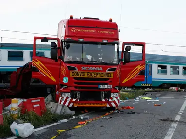 Bangkai sebuah truk terlihat di sebelah rangkaian kereta api yang keluar jalur setelah terlibat kecelakaan di dekat wilayah Turin, Italia, Kamis (24/5). Truk itu dihantam kereta yang mengakibatkan dua orang tewas dalam kejadian ini. (AP/Antonio Calanni)