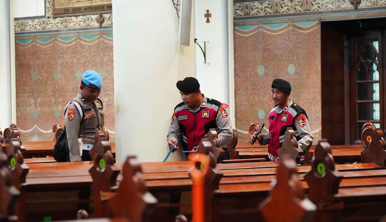 Sterilisasi gereja untuk menjamin rasa aman umat Kristiani dalam menjalankan ibadah menyambut Natal. Tampak dalam foto, personel dari regu penjinak bom kepolisian Indonesia memeriksa deretan kursi di dalam gereja selama operasi keamanan menjelang perayaan Natal di Katedral Bunda Maria Diangkat ke Surga atau Gereja Katedral Jakarta, Selasa 23 Desember 2025. (AP Photo/Tatan Syuflana)