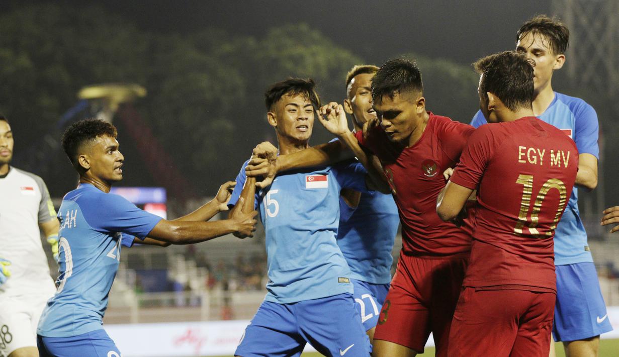 Pemain Timnas Indonesia U-22, Rachmad Irianto, melerai Egy Maulana, saat bersitegang dengan pemain Singapura U-22 pada laga SEA Games 2019 di Stadion Rizal Memorial, Manila, Kamis (28/11). Indonesia menang 2-0 atas Singapura. (Bola.com/M Iqbal Ichsan)