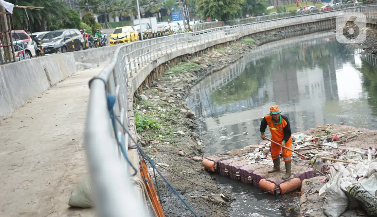 Petugas membersihkan sampah di sepanjang Kali Taman Anggrek, Jakarta, Rabu (8/7/2020). Banyaknya limbah menyebabkan Kali Taman Anggrek menjadi berwarna hitam dan berbau tidak sedap meskipun dibersihkan setiap hari. (Liputan6.com/Immanuel Antonius)