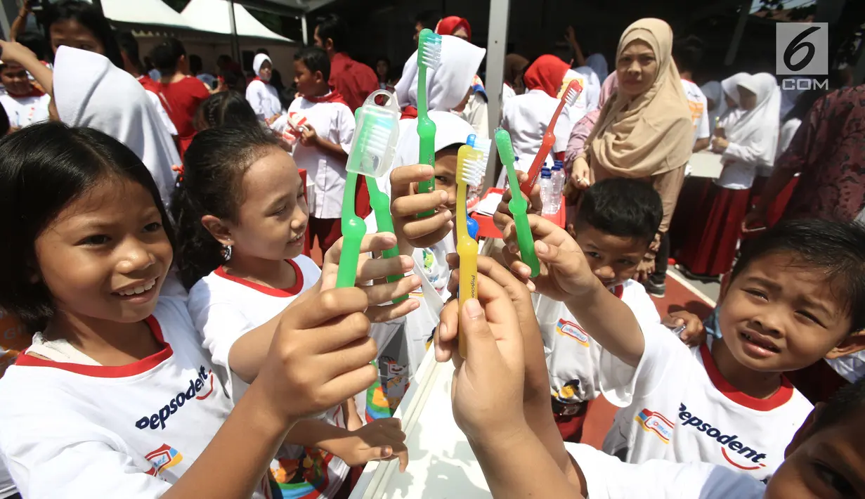 Sejumlah anak menunjukkan sikat giginya saat memperingati Kesehatan Gigi dan Mulut Sedunia 2018 di SDN Tebet Timur 01 Pagi, Jakarta, Selasa (20/3). (Liputan6.com/Pool/Doni)
