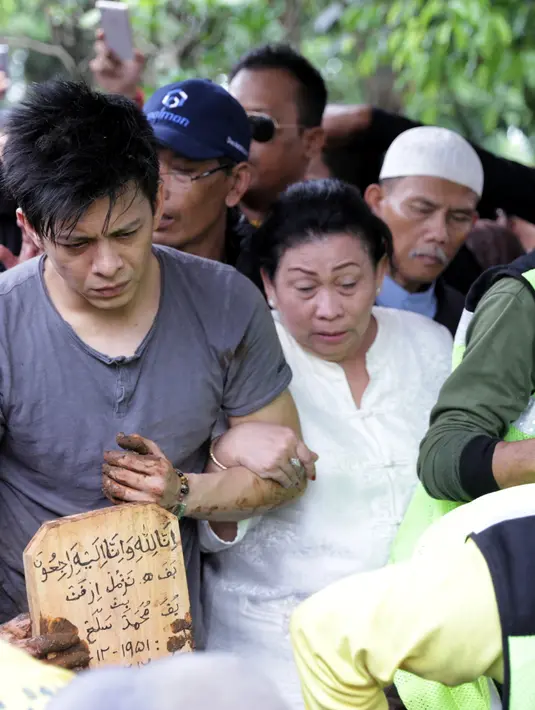 Ariel NOAH tampak setia memegang pusara milik Almarhum ayahanda. (Adrian Putra/Bintang.com)