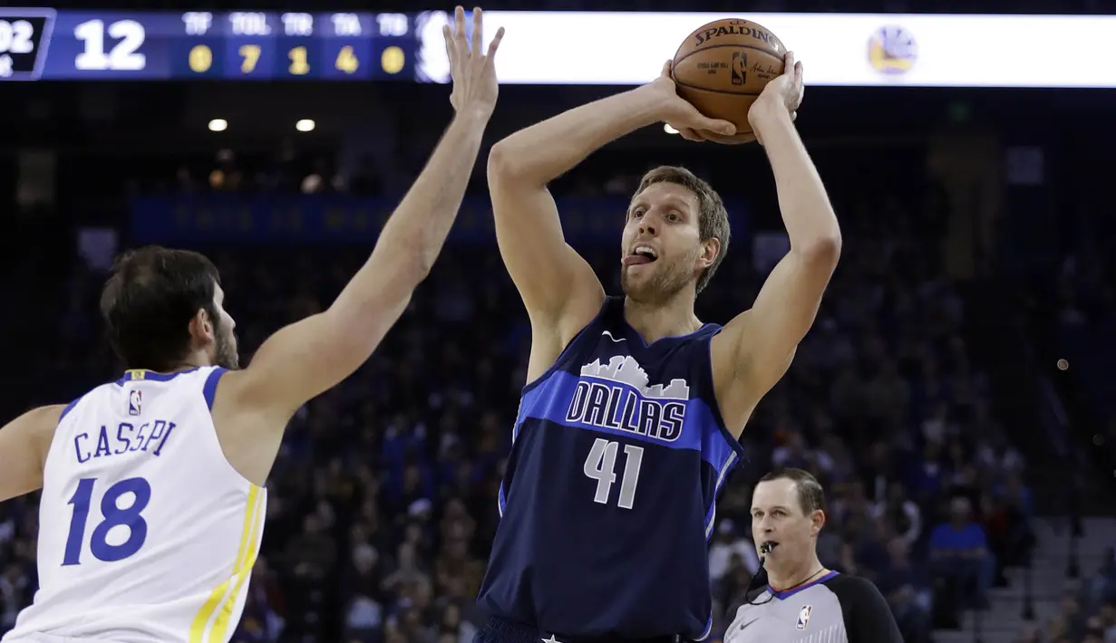 Pebasket Dallas Mavericks, Dirk Nowitzki, berusaha melewati pebasket Golden State Warriors, Omri Casspi, pada laga NBA di Oracle Arena, Oakland, Kamis (14/12/2017). Warriors menang 112-97 atas Mavericks. (AP/Marcio Sanchez)
