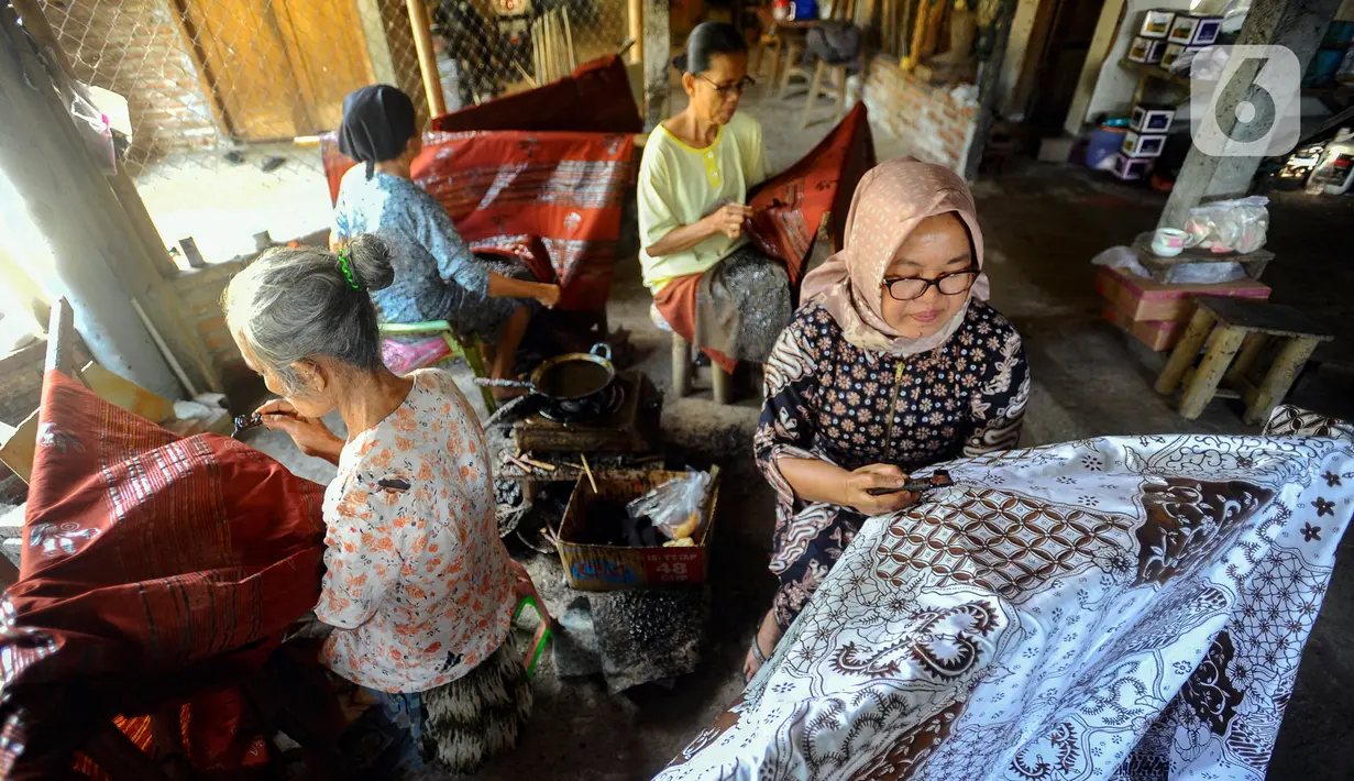 Para perajin menyelesaikan pembuatan batik tulis di Tie Poek Batik, Trenggalek, Jawa Timur, Sabtu (2/9/2023). Batik tulis corak Trenggalek didominasi bunga cengkeh. (merdeka.com/Arie Basuki)