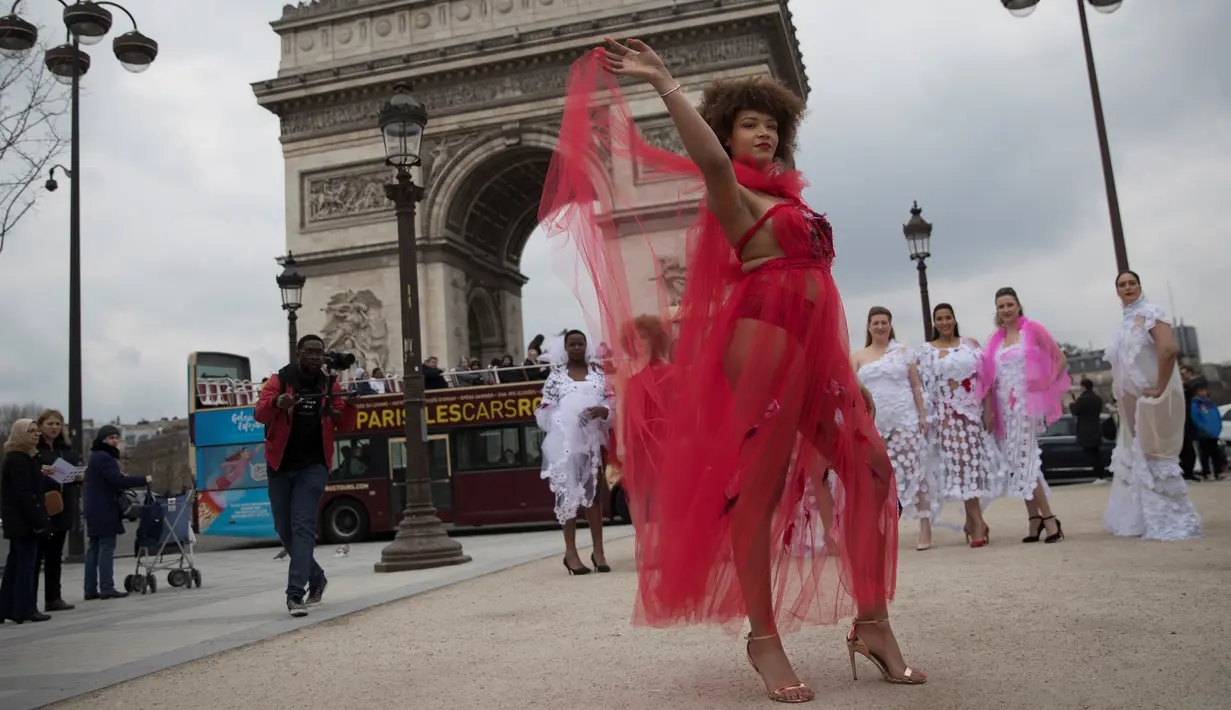 Seorang model ukuran plus bergaya saat tampil di depan Triump Arch di Paris, Prancis (4/1). Acara ini bertujuan mempromosikan keragaman yang bertema "All Sizes Catwalk". (AFP/Thomas Samson)