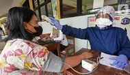 Petugas kesehatan dari Puskesmas Kecamatan Matraman melakukan skrining saat vaksinasi COVID-19 di SD Negeri 25 Utan Kayu Selatan, Matraman, Jakarta Timur, Rabu (23/3/2022). Vaksin yang digunakan adalah vaksin AstraZeneca untuk dosis pertama, kedua dan ketiga (booster). (Liputan6.com/Herman Zakharia)