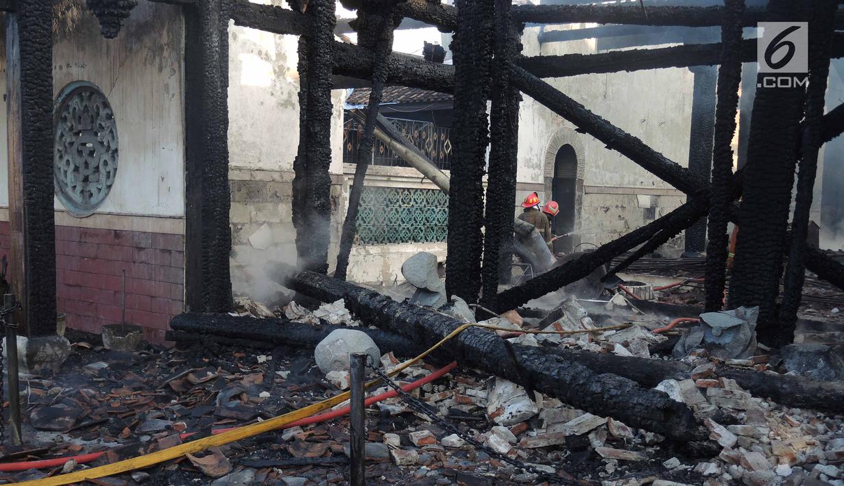 Petugas damkar mendinginkan sisa kebakaran yang melanda kompleks Kelenteng Tay Kak Sie di Gang Lombok, Semarang, Kamis (21/3). Bangunan yang terbakar merupakan rumah abu yang berada satu kompleks dengan bangunan utama kelenteng. (Liputan6.com/Gholib)