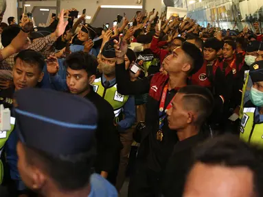 Skuad Timnas Indonesia U-22 yang berhasil mempersembahkan medali emas cabor sepak bola SEA Games 2023 tiba di Terminal 3 Kedatangan Bandara Soekarno Hatta, Kamis (18/5/2023) malam WIB. Rizky Ridho dkk disambut meriah puluhan suporter, termasuk beberapa keluarga pemain. Lagu "Champione" berkumandang saat prosesi pengalungan bunga yang dilakukan oleh Waketum PSSI, Zainudin Amali dan beberapa perwakilan Kemenpora, CdM dan KOI. (Bola.com/Bagaskara Lazuardi)