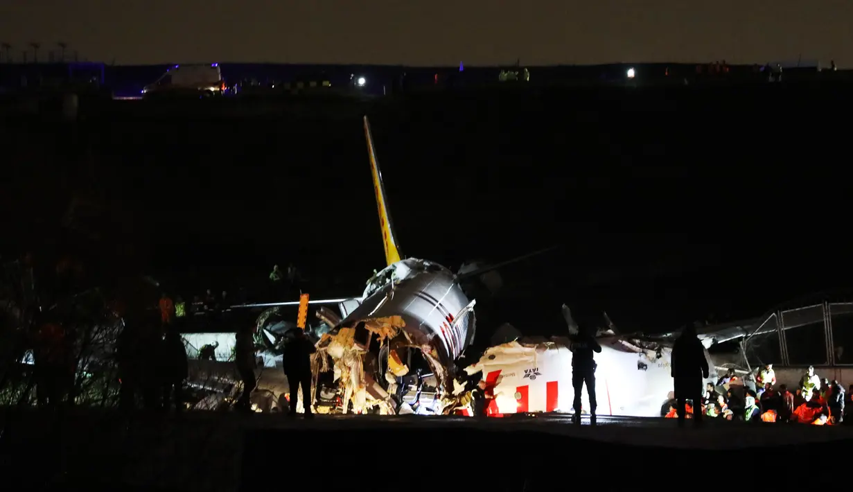 Tim penyelamat bekerja setelah sebuah pesawat tergelincir di landasan pacu Bandara Sabiha Gokcen, Istanbul, Turki, Rabu (5/2/2020). Pihak berwenang mengatakan sebanyak 52 orang terluka dalam kejadian tersebut. (AP Photo)