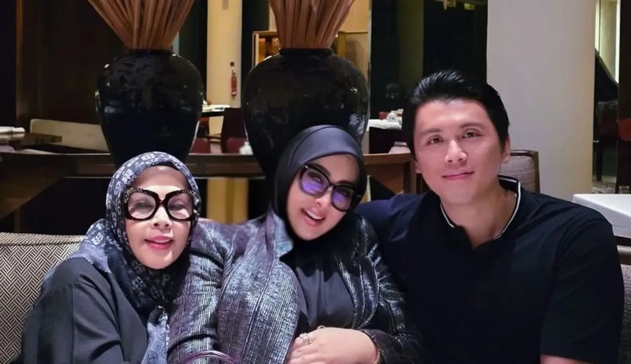 Makan bersama suami dan ibunya, Syahrini mengenakan pakaian serba hitam. Dari dress, outer, hingga kerudungnya. Ia membawa tas Hermes ungu model kelly doll matte alligator & swift leather with palladium hardware senilai Rp 2.240.000.000. [@princessyahrini]