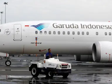 Teknisi mengendarai mobil melewati pesawat Boeing 737 Max 8 Garuda Indonesia yang terparkir di Bandara Soekarno Hatta, Tangerang, Rabu (13/3). Pemerintah menetapkan pelarangan permanen untuk pesawat Boeing 737 Max 8 terbang. (REUTERS/Willy Kurniawan)