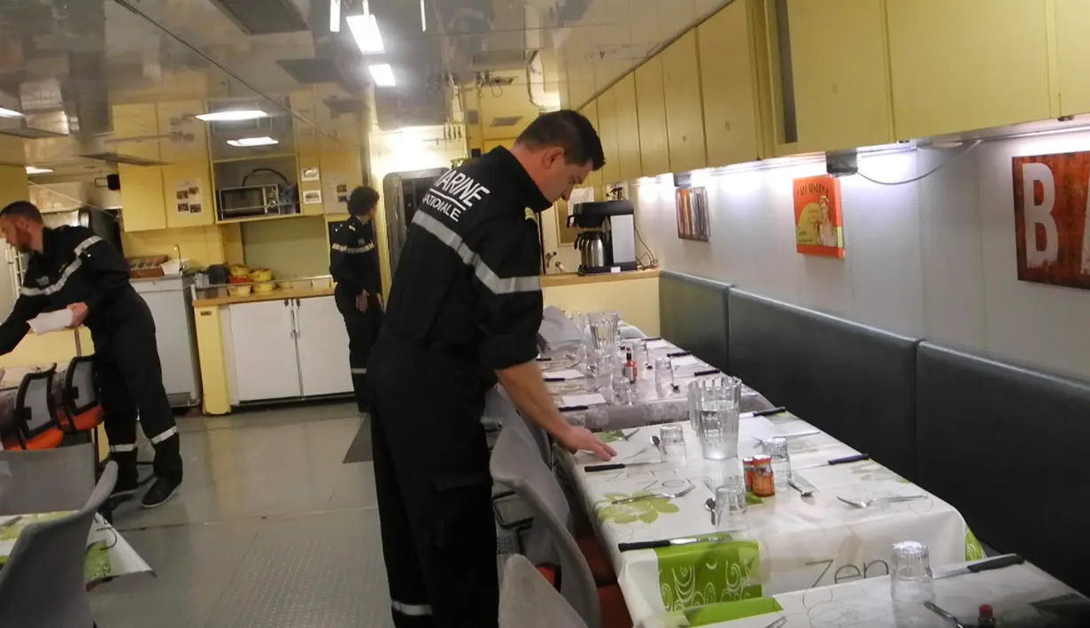 Pekerja menyiapkan makanan diruang makan untuk para awak kapal kapal selam nuklir Triumphant "Le Vigilant", Brest, Perancis (21/10). Ketika kapal menyelam, para awak dikunci dalam lambung kapal selam selama 2-3 bulan di laut. (AFP /Valérie Leroux)