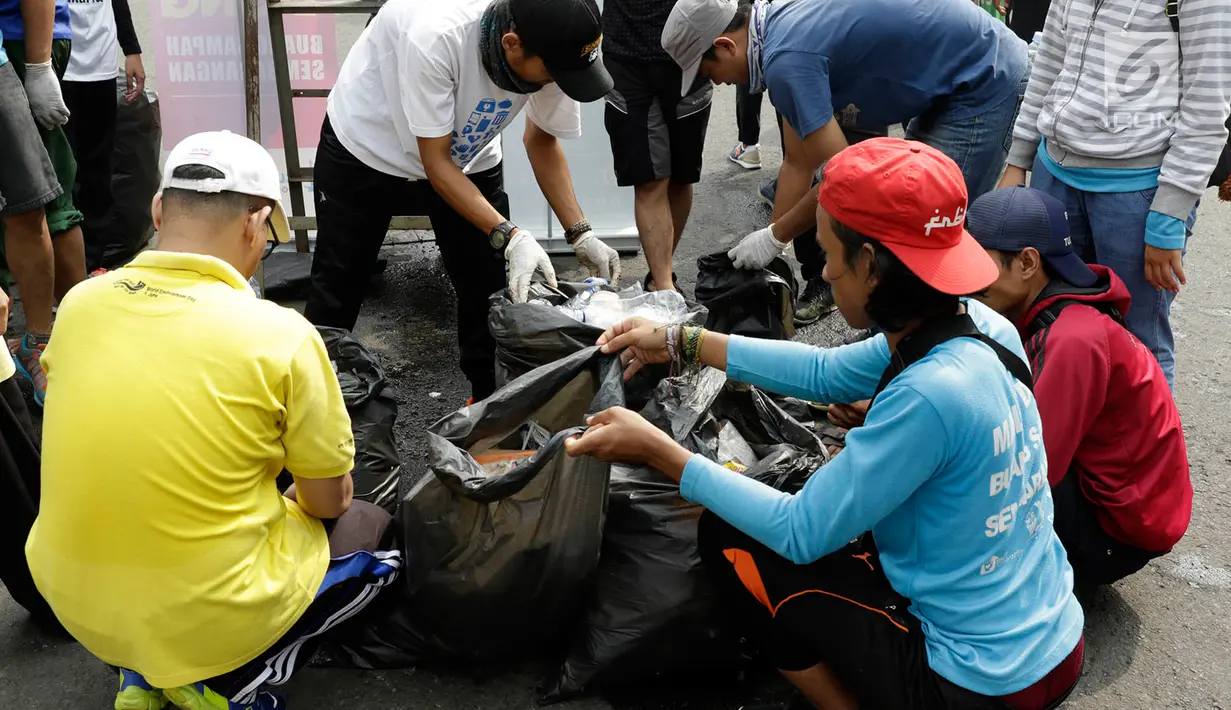 Relawan mengumpulkan sampah di lokasi Car Free Day (CFD), Jakarta, Minggu (21/5). Kegiatan tersebut diadakan untuk mengajak masyarakat agar peduli dengan kebersihan lingkungan serta selalu membuang sampah pada tempatnya. (Liputan6.com/Immanuel Antonius)