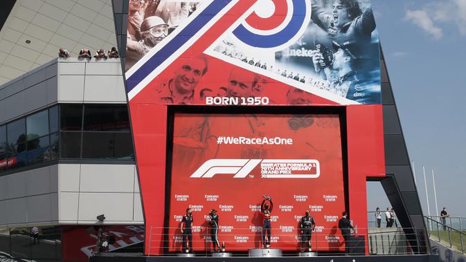 Pembalap Red Bull Max Verstappen (tengah) merayakan kemenangan pada 70th Anniversary Formula 1 Grand Prix di Sirkuit Silverstone, Silverstone, Inggris, Minggu (9/8/2020). Max Verstappen sukses menjadi yang tercepat dalam F1 GP Silverstone 2020. (Andrew Boyers, Pool via AP)