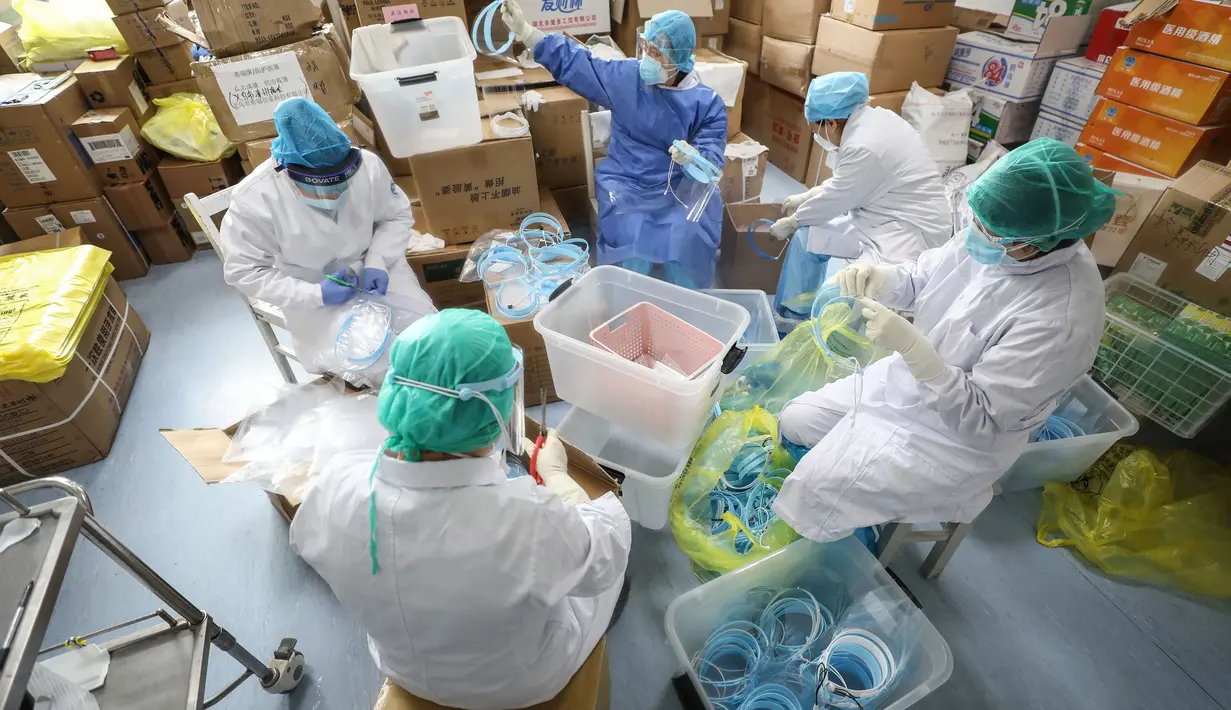 Petugas medis memasang topeng pelindung di Rumah Sakit Palang Merah di Wuhan, 28 Februari 2020. Virus Corona yang bermula di China tengah pada Desember 2019 kini menyebar secara global di mana lima negara terdampak paling besar, yakni Cina daratan, Korea Selatan, Iran, Italia dan Jepang (STR/AFP)