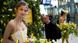 Model tersenyum saat mengenakan gaun berhiaskan bunga-bunga saat berlangsungnya pameran bunga Keukenhof di Central Station di Utrecht, Belanda, (29/3). Pameran ini menghadirkan sekitar 20.000 bunga musim semi. (AP Photo / Peter Dejong)