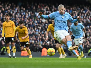 Penyerang Manchester City, Erling Haaland melakukan tendangan penalti dan mencetak gol kedua timnya ke gawang Wolves selama pertandingan lanjutan Liga Inggris di Stadion Etihad di Manchester, Inggris (22/1/2023). Manchester City menang telak atas Wolves 3-0. (AFP/Paul Ellis)