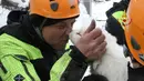 Seorang petugas pemadam kebakaran Italia mencium anak anjing yang selamat dari reruntuhan Hotel Rigopiano di Farindola, Italia (23/1). Sebelumnya, longsoran salju telah melanda Hotel Rigopiano di Kota Farindola. (Fabio Gatto/ Vigili Del Fuoco / AFP)