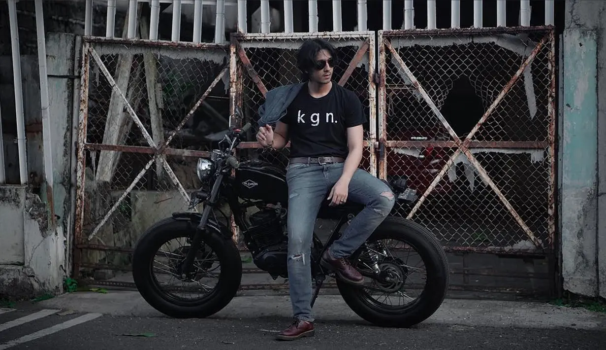 Arya Saloka terlihat cool dengan rambut gondrong dan kacamata hitam. Dipadupadankan dengan jeans robek-robek dan kaos hitam menambah kesan nakal. (Instagram/arya.saloka)