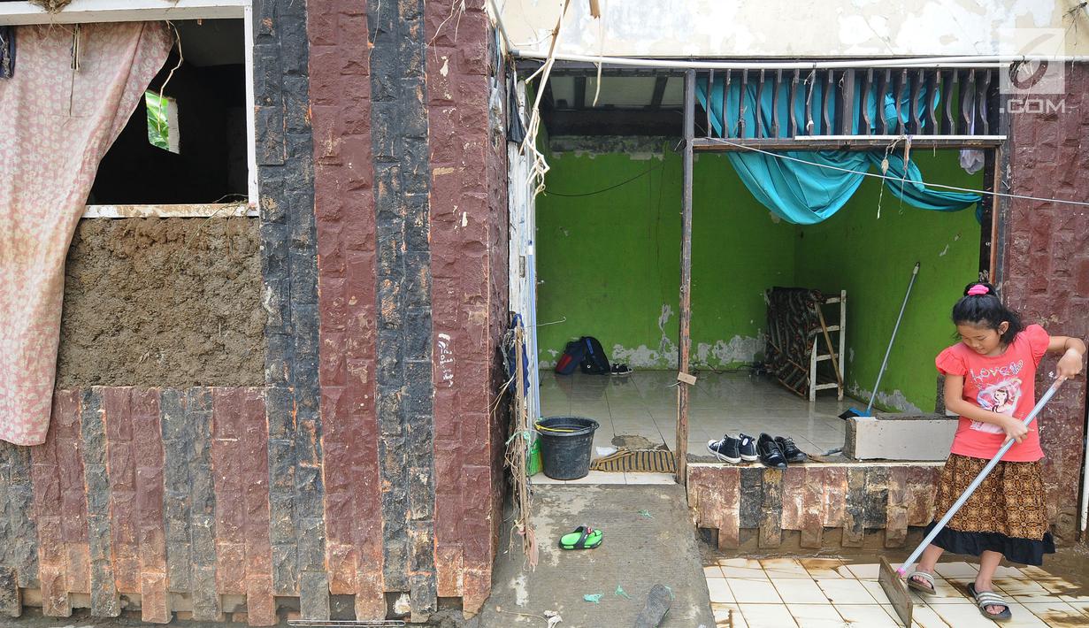 Seorang anak membersihkan lumpur pada teras rumah usai banjir melanda kawasan  Balekambang, Kramatjati, Jakarta Timur, Selasa (30/4/2019). Sejumlah rumah warga di RT 005/RW 005 Balekambang rusak diterjang banjir yang terjadi pada 27 April 2019 lalu. (Liputan6.com/Herman Zakharia)