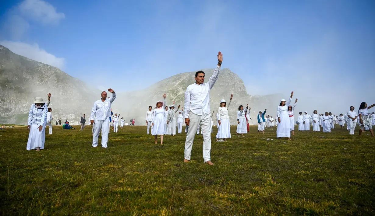 Anggota gerakan keagamaan internasional Persaudaraan Putih melakukan ritual tarian di puncak Gunung Rila, dekat Danau Babreka, Bulgaria, 19 Agustus 2021. Tarian seperti kosmik yang ditampilkan dalam lingkaran konsentris menciptakan citra mencolok di puncak Gunung Rila. (NIKOLAY DOYCHINOV/AFP)