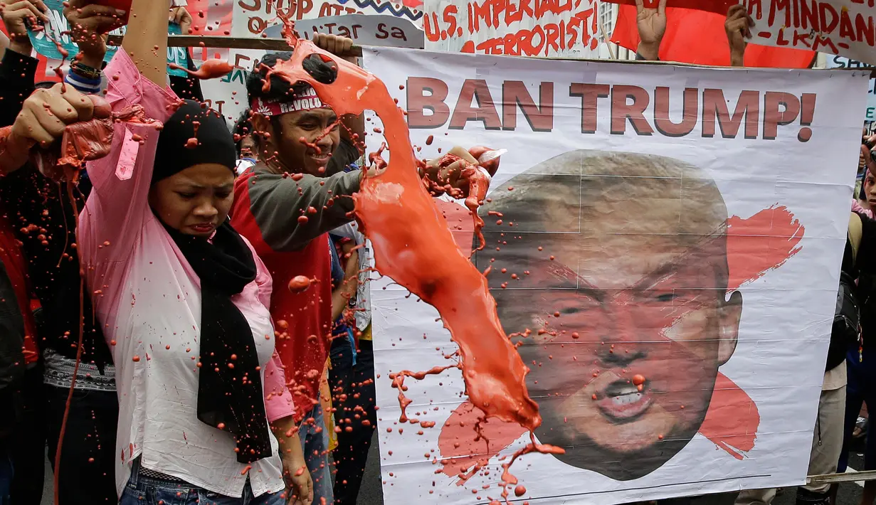 Sejumlah orang menggelar aksi unjuk rasa di dekat Kedutaan Besar AS di Manila, Filipina (11/11). Mereka menggelar aksi untuk memprotes kunjungan Presiden AS, Donald Trump ke Filipina. (AP Photo/Aaron Favila)
