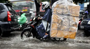 Sejumlah kendaraan melintasi genangan air di Jalan Iskandar, Jakarta, Kamis (22/1/2015). (Liputan6.com/Miftahul Hayat)