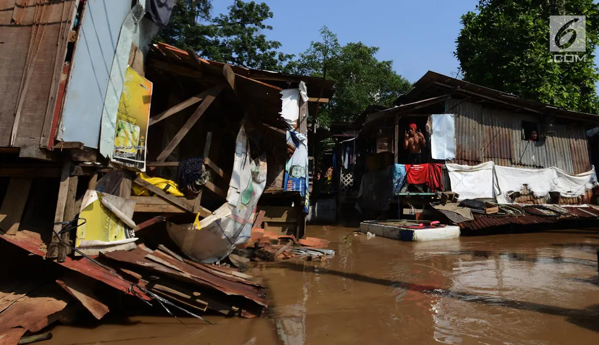 Warga berada dirumahnya saat banjir di kampung Arus Cawang, Jakarta Timur, Jumat (26/4). Ketinggan banjir kurang lebih satu meter terjadi akibat luapan kali Ciliwung dan intensitas curah hujan di kawasan Bogor Jawa Barat sangat tinggi sehingga aktivitas warga terhambat. (merdeka.com/Imam Buhori)