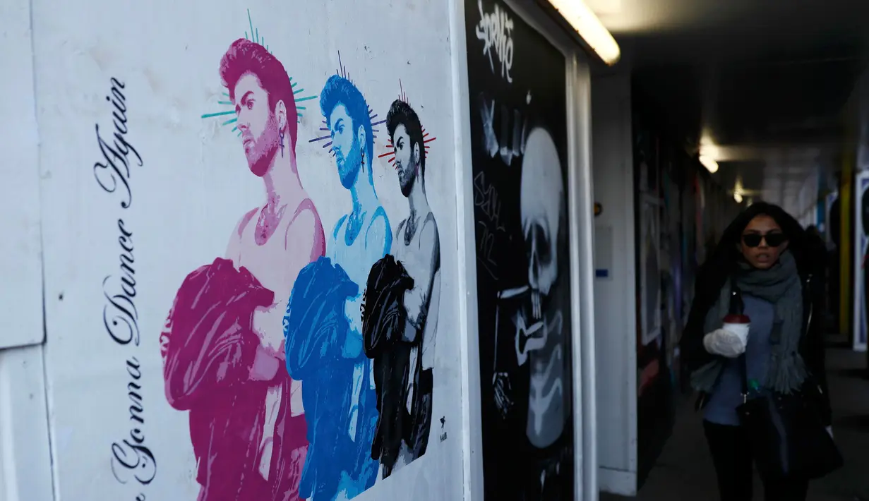 Pejalan kaki melintas dekat gambar mural musisi asal Inggris, George Michael, di Shoreditch, London timur, 29 Desember 2016. Gambar itu menampilkan George Michael mencengkram jaket dan terdapat tulisan 'Never Gonna Dancer Again'. (REUTERS/Stefan Wermuth)