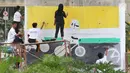 Siswa SMK N 46 Jakarta menggambar mural di bawah kolong jalan layang non tol Kasablangka, Jakarta, Jumat (1/12). Mural tersebut di lakukan untuk mempercantik kawasan tersebut. (Liputan6.com/Angga Yuniar)