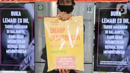 Petugas sharp menunjukkan kantong berisi makanan dan minuman yang merupakan sumbangan dari warga di Halte Dukuh Atas, Jakarta, Rabu (05/5/2021). Makanan yang disimpan di lemari es akan didistribusikan ke yayasan sosial atau warga yang membutuhkan. (Liputan6.com/Fery Pradolo)
