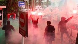 Suporter Timnas Indonesia, Ultras Garuda, menyalakan flare saat menggelar aksi unjuk rasa di depan Kantor PSSI, GBK Arena, Senayan, Jakarta Pusat, Jumat (14/11/2025). (Bola.com/M Iqbal Ichsan)