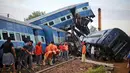 Pekerja memperbaiki rel dekat sebuah kereta api yang tergelincir hingga keluar jalur di Negara Bagian Uttar Pradesh, India, Minggu (20/8). Kecelakaan ini merupakan insiden yang melibatkan kereta penumpang keempat pada tahun ini. (AP/Altaf Qadri)