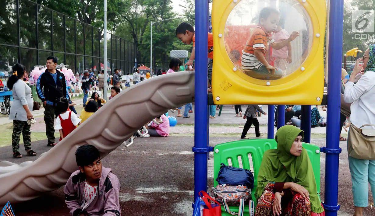 Anak-anak bermain seluncur di Lapangan Banteng, Jakarta, Minggu (14/10). Lapangan Banteng yang dahulu sepi sekarang menjadi tempat favorit warga untuk mengajak anaknya bermain. (Liputan6.com/JohanTallo)