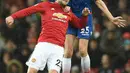 Striker Stoke City, Peter Crouch berebut bola dengan bek Manchester United, Luke Shaw pada laga pekan ke-23 Premier League 2017-2018 di Old Trafford, Senin (15/1). Manchester United mencetak tiga gol tanpa balas di kandnag sendiri. (Oli SCARFF/AFP)