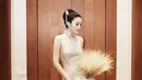 Sandra Dewi tampil anggun dalam balutan cheongsam model mermaid nuansa emas yang cantik saat tea pai. [Instagram].