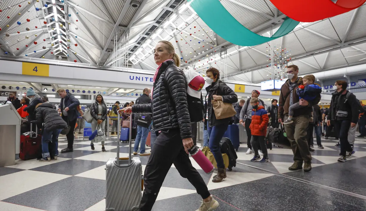 Wisatawan tiba untuk penerbangan di Terminal 1 United Airlines menjelang Liburan Natal di Bandara Internasional O'Hare di Chicago (22/12/2022). Peramal cuaca AS memperingatkan cuaca yang mengancam jiwa karena badai musim dingin mengancam akan mendatangkan malapetaka pada rencana perjalanan liburan bagi jutaan orang Amerika. (AFP/Kamil Krzaczynski)