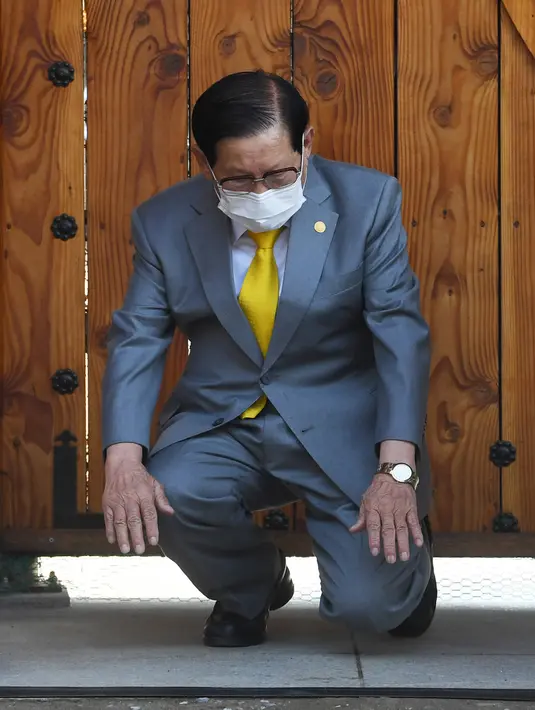 Pemimpin sekte Gereja Shincheonji Yesus, Lee Man-hee berlutut dan membungkuk untuk meminta maaf kepada publik saat konferensi pers di Gapyeong, Senin (2/3/2020). Pemimpin sekte tersebut meminta maaf karena jemaatnya menjadi penyebab penyebaran wabah virus corona di Korea Selatan. (POOL/AFP)