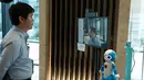 Sebuah robot memeriksa suhu tubuh seorang pria dalam uji coba yang dilakukan di sebuah bangunan komersial di Tokyo, Jepang (14/9/2020). Ajang ini untuk menguji coba cara kerja robot dalam memandu, memeriksa suhu, telepresensi, dan sejumlah fungsi lainnya. (Xinhua/Pemerintah Kota Metropolitan Tokyo)