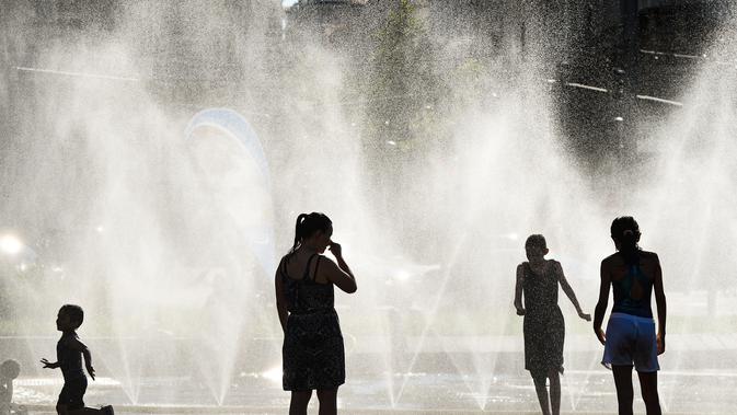 Sejumlah warga menyejukkan diri di dekat semprotan air di Schwarzenbergplatz di Wina, Austria (28/7/2020). Suhu tertinggi di Wina mencapai angka 37,2 derajat Celsius pada Selasa (28/7). (Xinhua/Guo Chen)