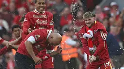 Pelatih Liverpool, Arne Slot dismprot oleh Harvey Eliott (kanan) dan Virgil van Dijk (kiri) saat merayakan gelar juara Liga Inggris 2024/2025 setelah mengalahkan Tottenham Hotspur di Anfield, Liverpool, Inggris, Minggu (27/04/2025). (AFP/Paul Ellis)