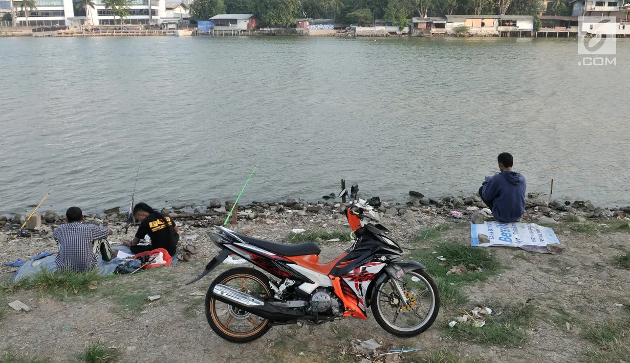 Warga memarkir sepeda motornya secara sembarangan saat memancing di Danau Sunter, Jakarta, Senin (22/7/2019). Tidak adanya fasilitas parkir di kawasan tersebut menyebabkan pengunjung Danau Sunter memarkirkan sepeda motor mereka secara sembarangan. (merdeka.com/Iqbal Nugroho)