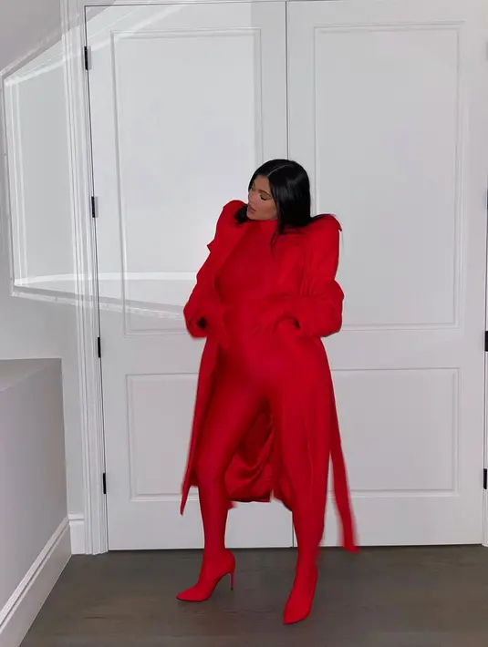Di sini, Kylie Jenner menampilkan baby bump-nya dengan mengenakan outfit serba merah, mulai dari bodysuit merah, ditumpuknya dengan long coat yang juga berwarna merah, dan high heels bernuansa senada. Foto: Instagram.