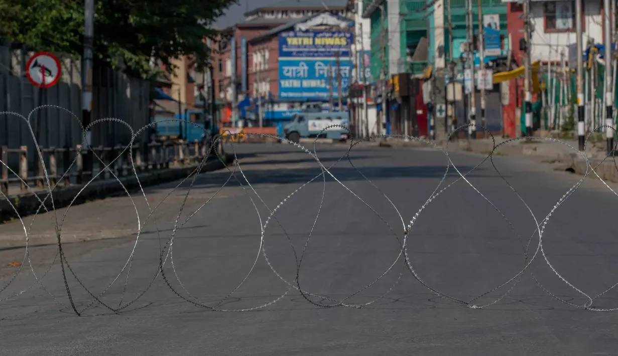Kawat berduri dipasang untuk memblokir jalan yang sepi di Srinagar, Kashmir yang dikuasai India, Rabu (5/8/2020). Pasukan dan barikade kawat berduri dikerahkan oleh India dalam upaya menahan serangan pada peringatan setahun pelepasan status otonomi khusus wilayah tersebut. (AP Photo/ Dar Yasin)