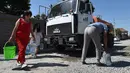 Di distrik-distrik selatan kota, penduduk bergantung pada botol-botol plastik berisi air yang didistribusikan oleh pemerintah kota saat suhu udara mendekati 40 derajat Celsius. (VYACHESLAV OSELEDKO / AFP)